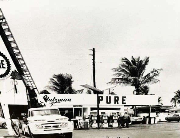 A black and white photo of a pure gas station