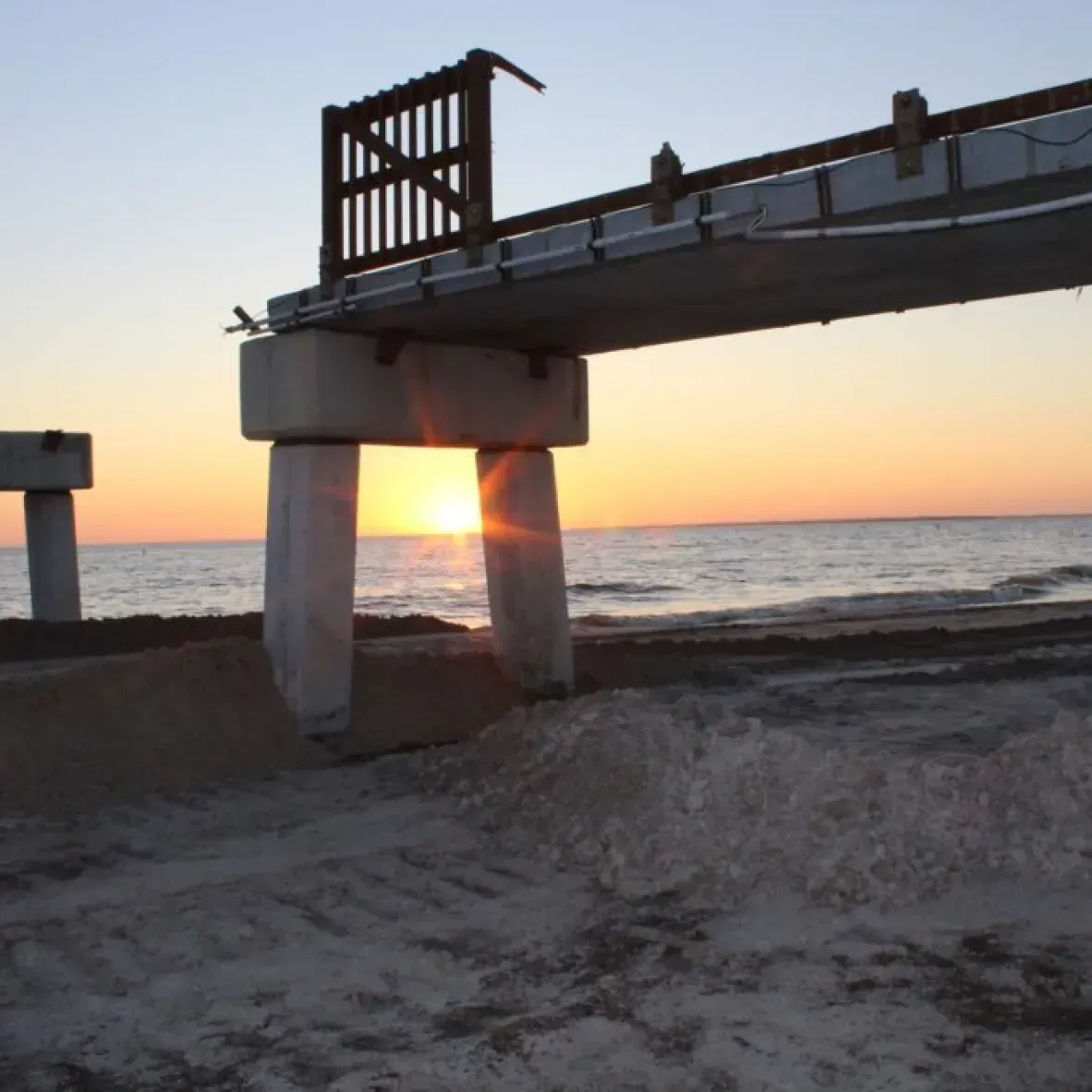 A bridge over a body of water at sunset