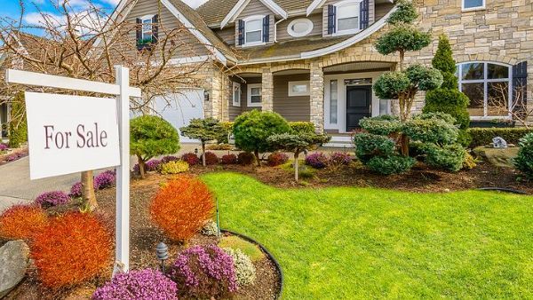 A house with a for sale sign in front of it.