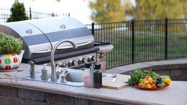 There is a grill and a sink in the backyard.