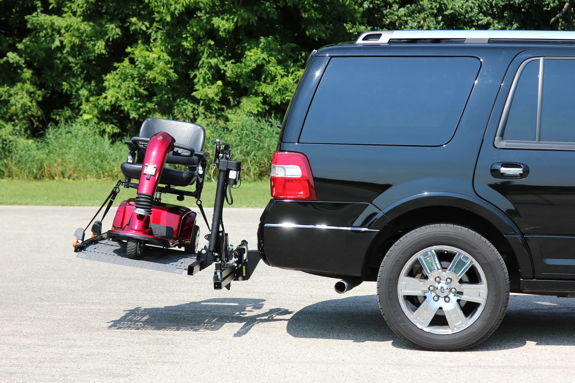 A mobility scooter on a black SUV with an automobile lift ASL-275 by bruno and installed by Altamira Ltd.