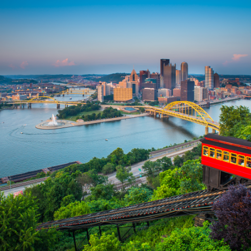 An aerial view of a city with a red train in the foreground