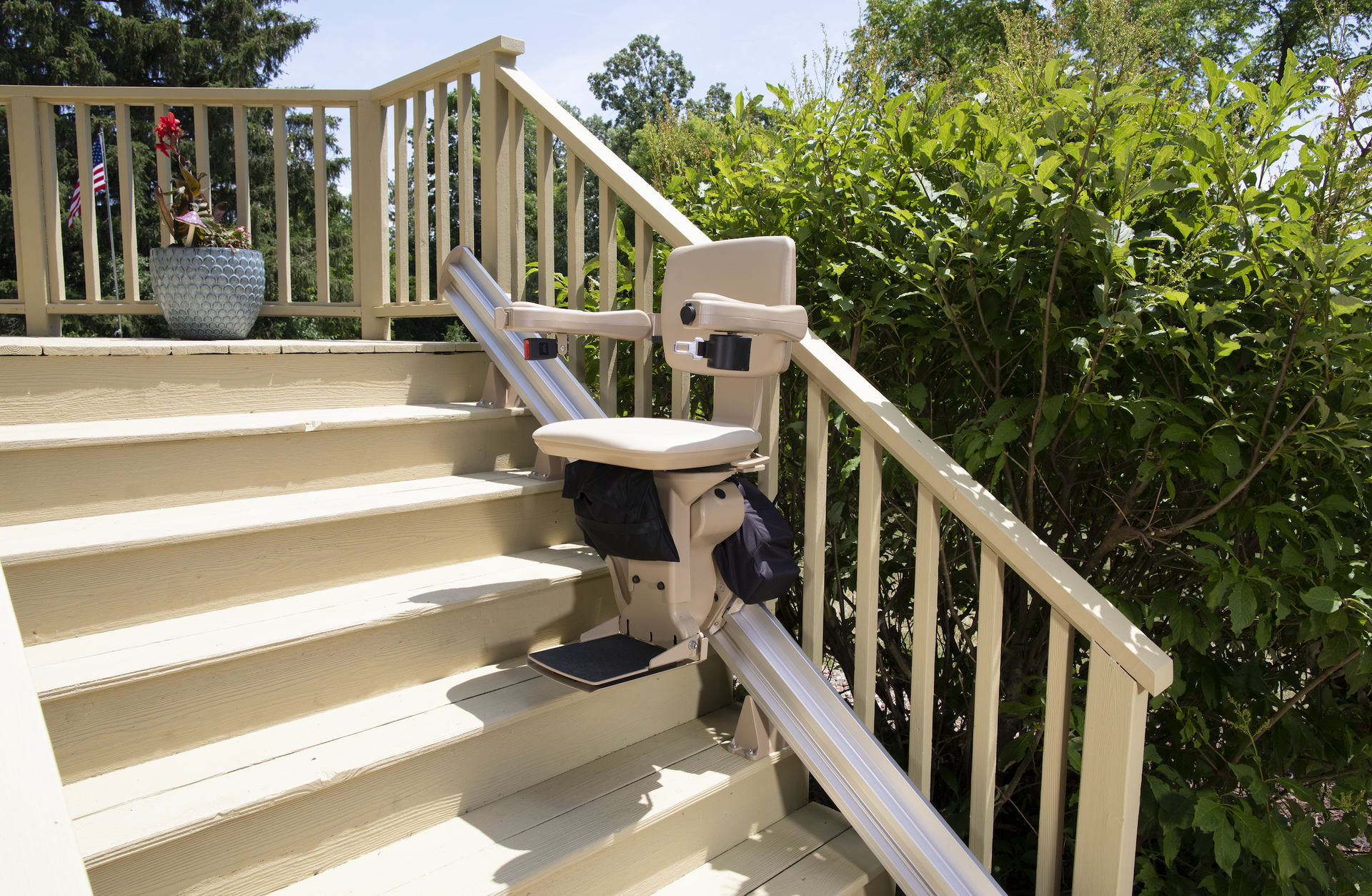 An outdoor straight stair lift is attached to the side of the stairs by Altamira Ltd.