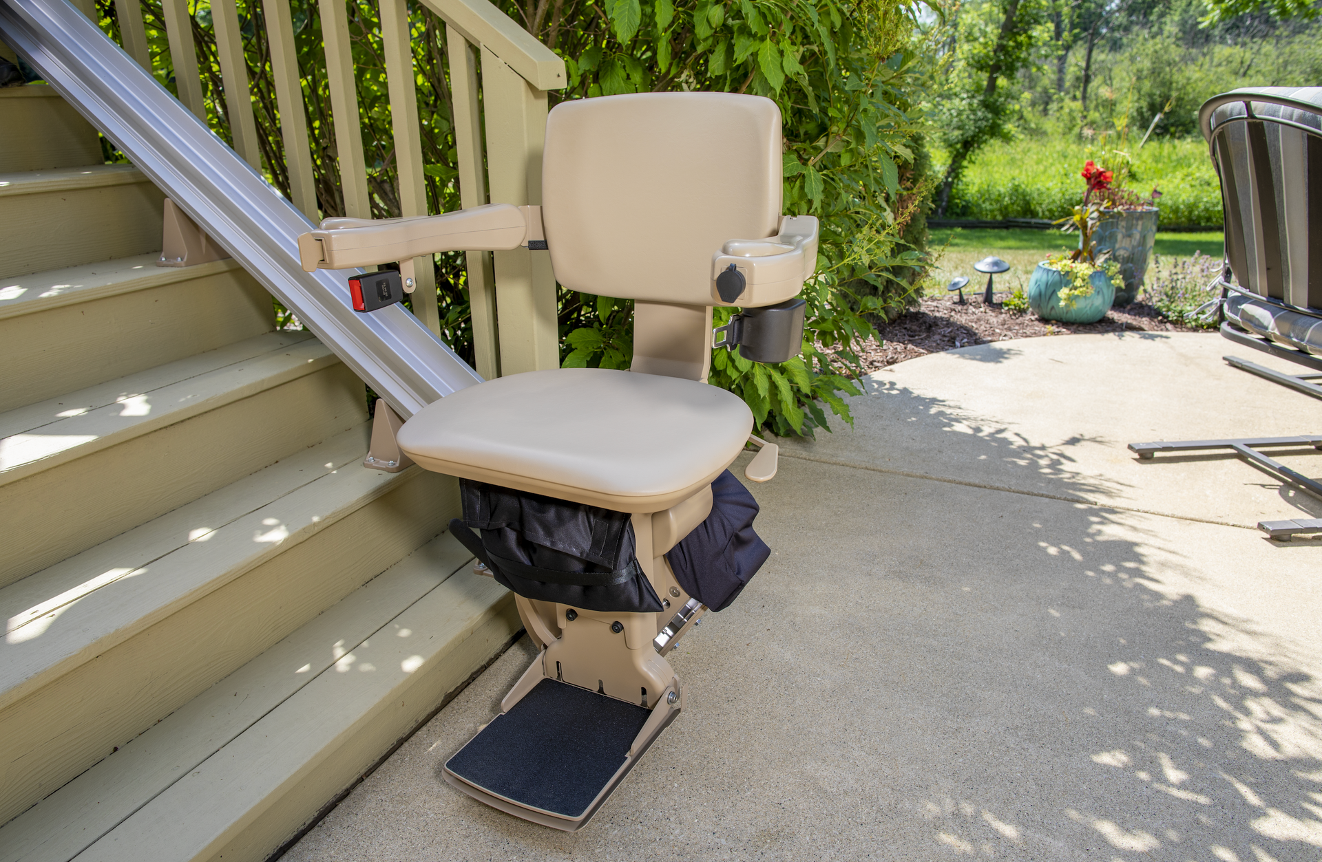 An outdoor stair lift is sitting on the side of a set of stairs.