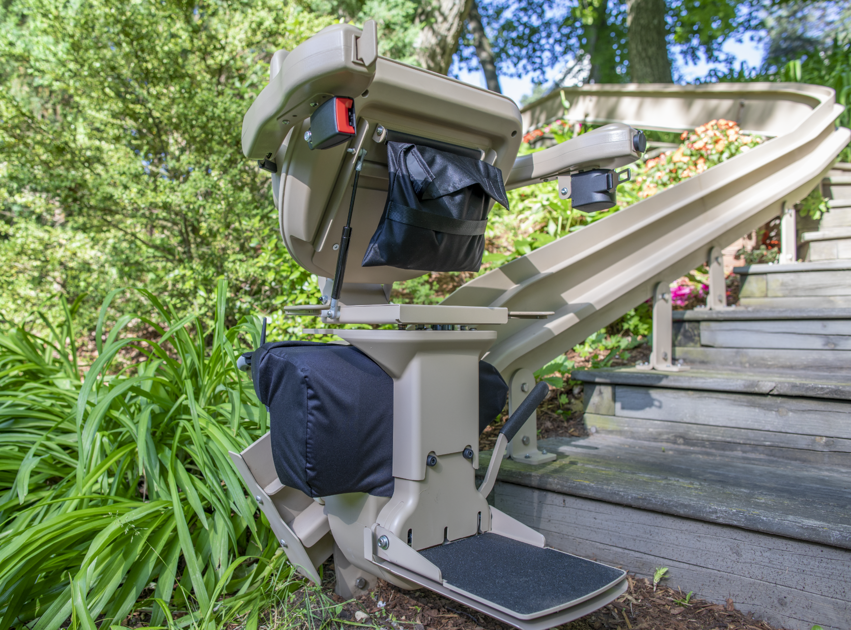 An outdoor stair lift is sitting on the side of a set of stairs.