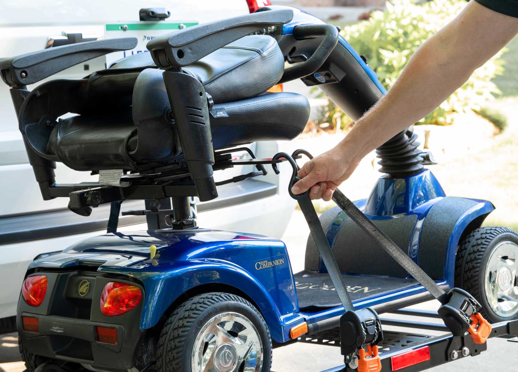 A person is loading a mobility scooter on a trailer.