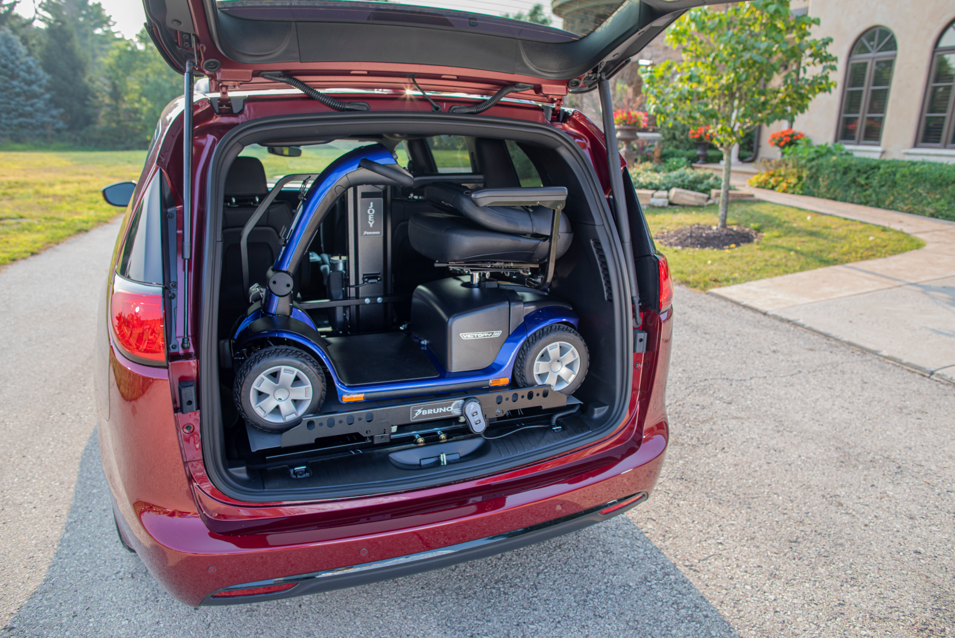 A mobility scooter is sitting in the back of a minivan.