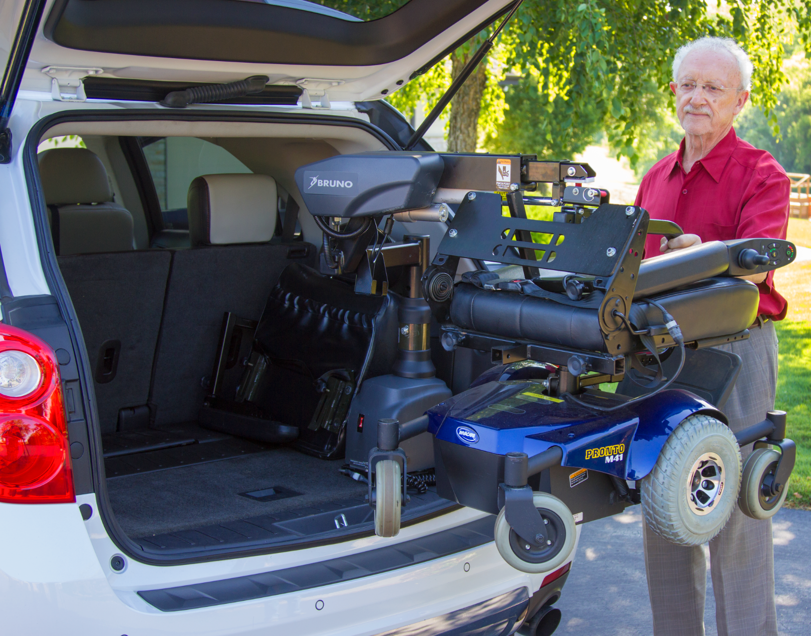 A man is loading a wheelchair into the back of a car