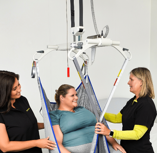 A man in a wheelchair is sitting on a ramp in front of a house.