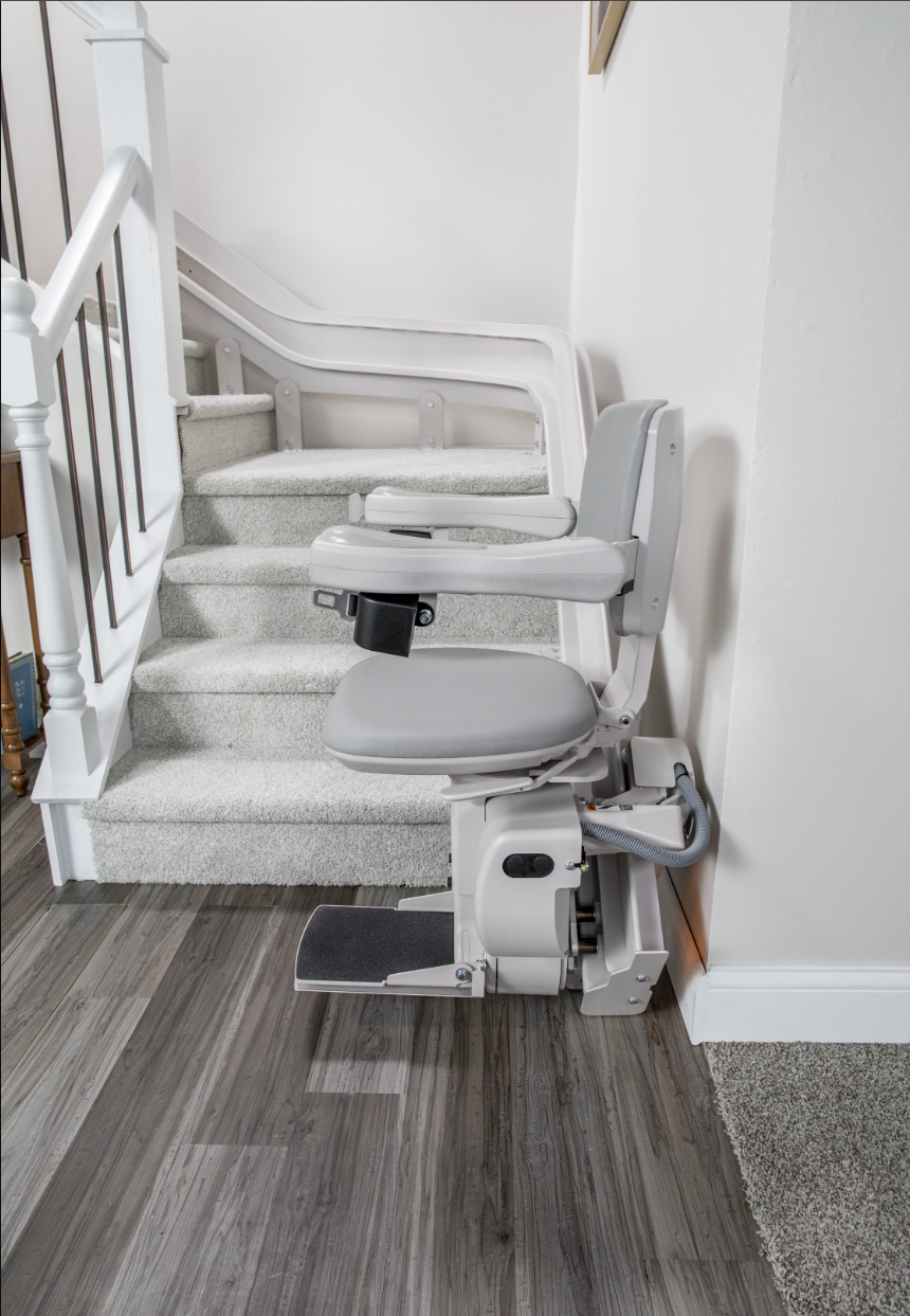 A stair lift is sitting on top of a set of stairs.