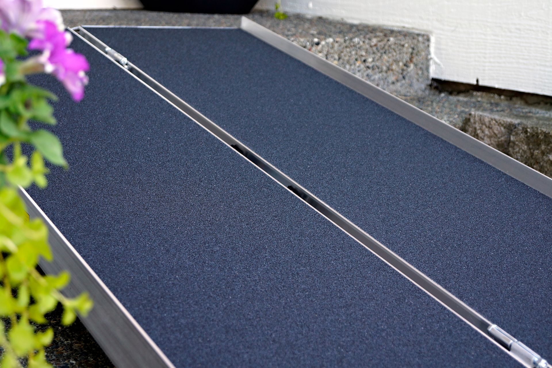 A close up of a ramp with purple flowers in the background.