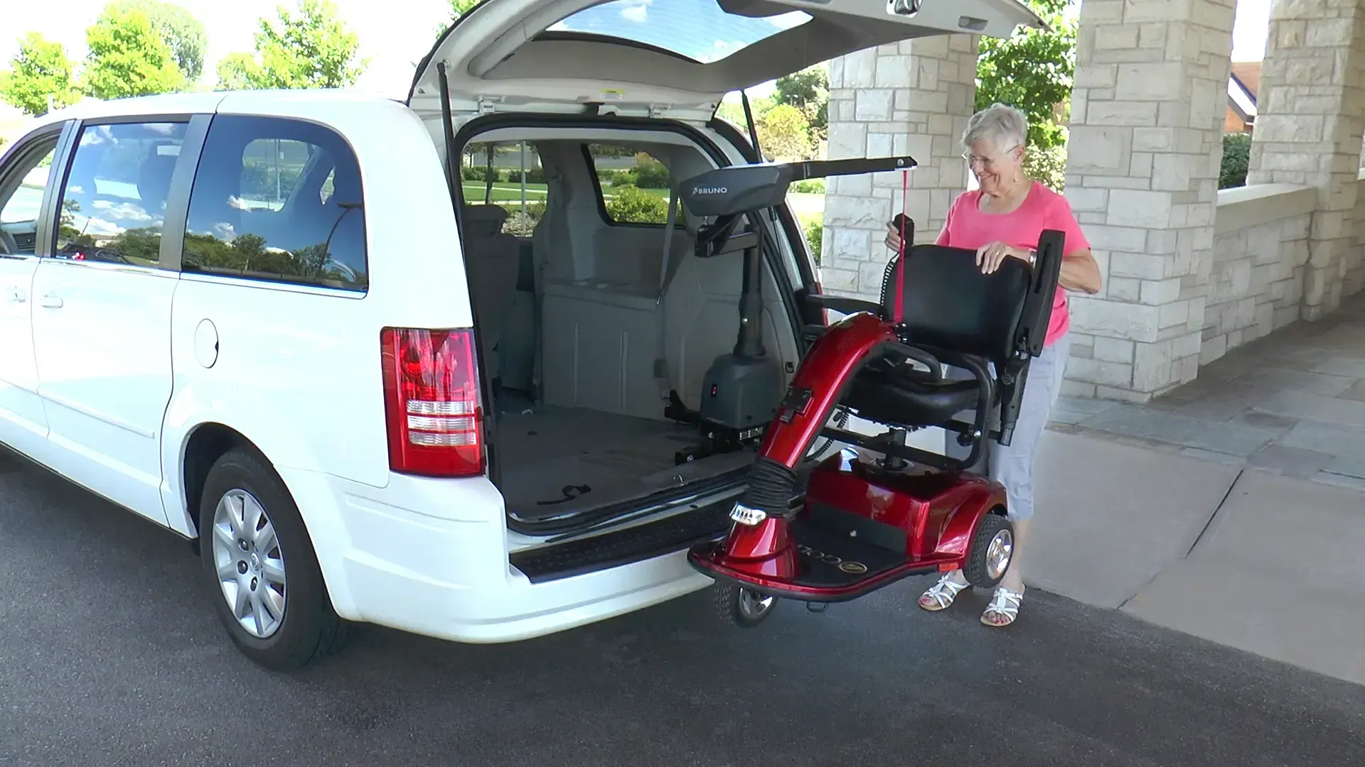 A white suv with a mobility scooter lift installed by Altamira Ltd.