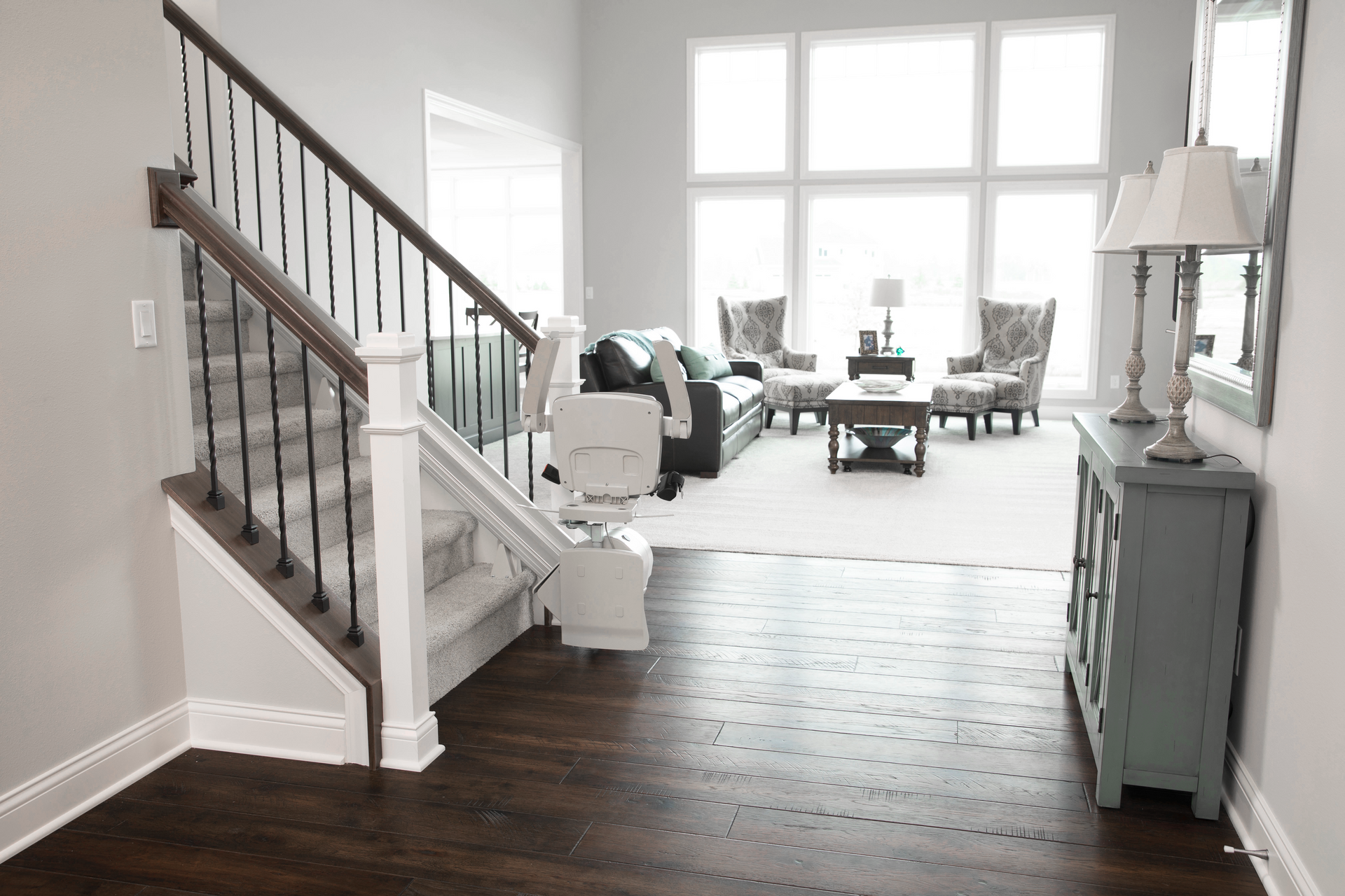 A living room with a staircase and stairlift by Altamira Ltd. leading up to the second floor.