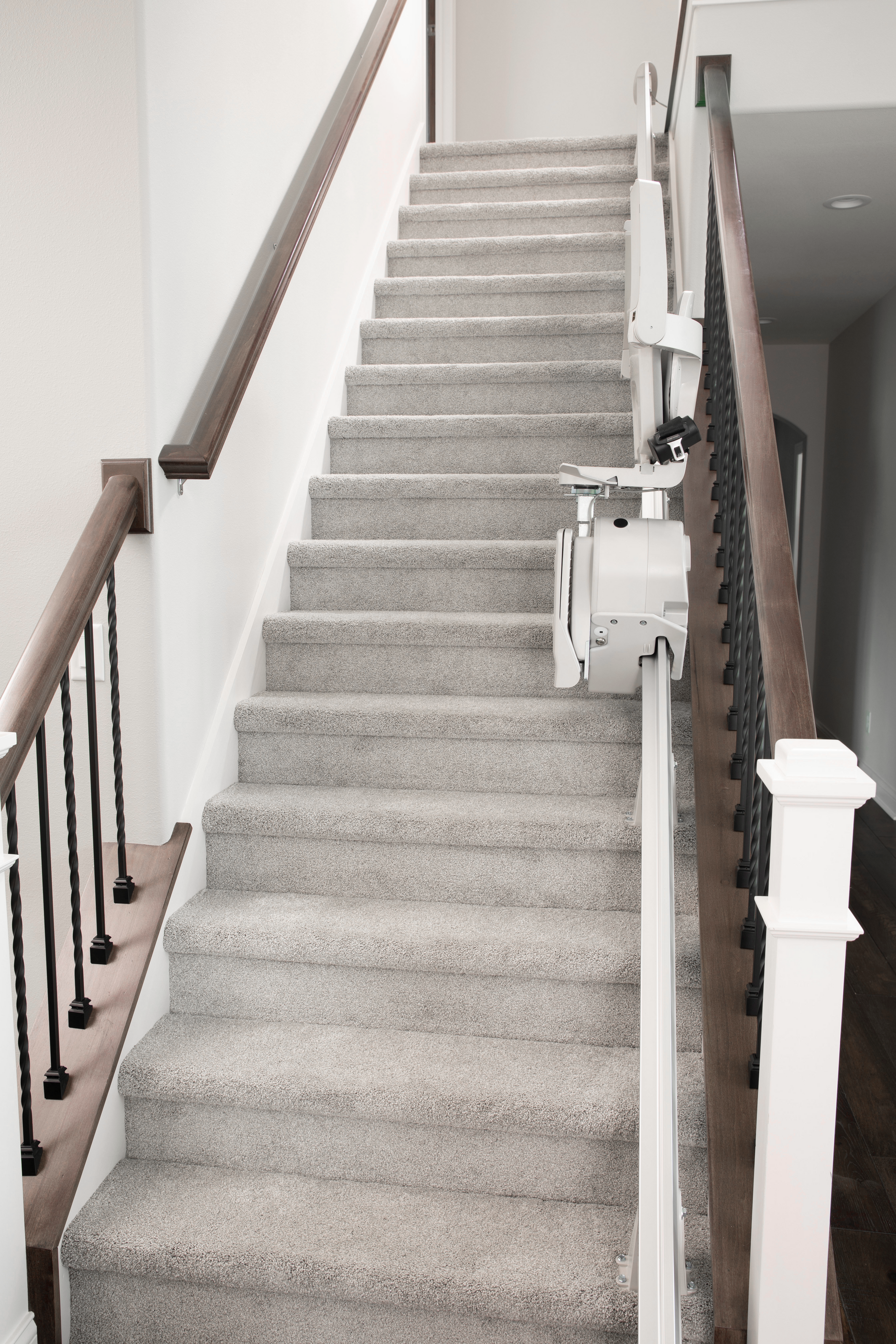 A set of stairs with a carpeted staircase and a wooden railing.