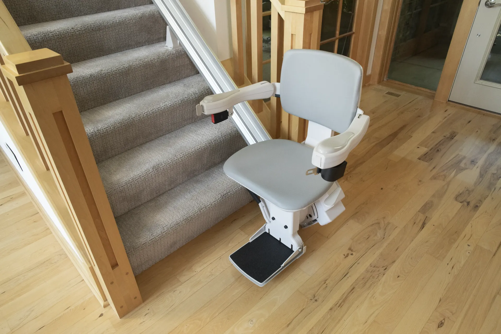 A Bruno Elite Indoor Straight stairlift is sitting next to a set of stairs.
