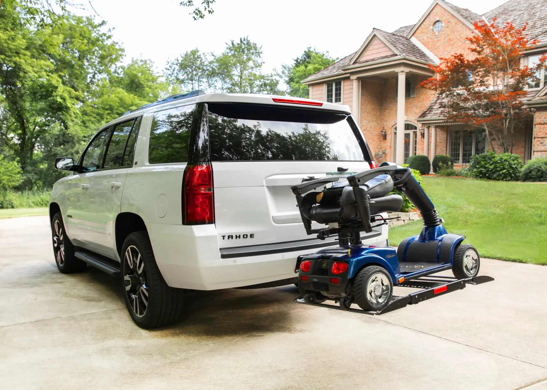 A white suv with a mobility scooter lift installed by Altamira Ltd.