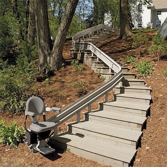 A set of stairs outside with an outdoor Bruno Elite Curved stairlift by Altamira ltd.
