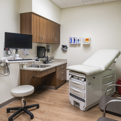 A doctor 's office with a stool and a desk