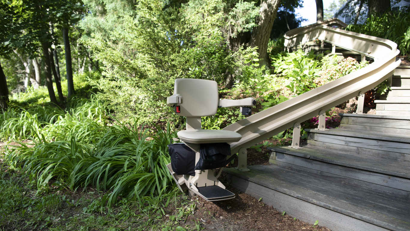 A stair lift is sitting on the side of a wooden walkway.