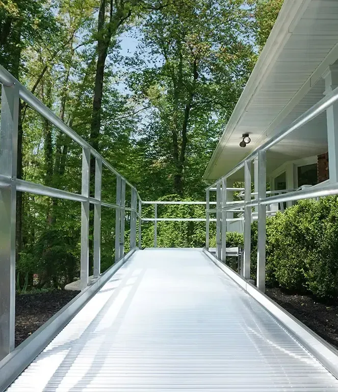 A ramp leading to a house with trees in the background