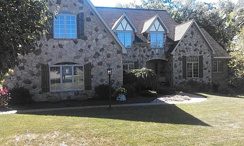 A large stone house with a lot of windows and shutters