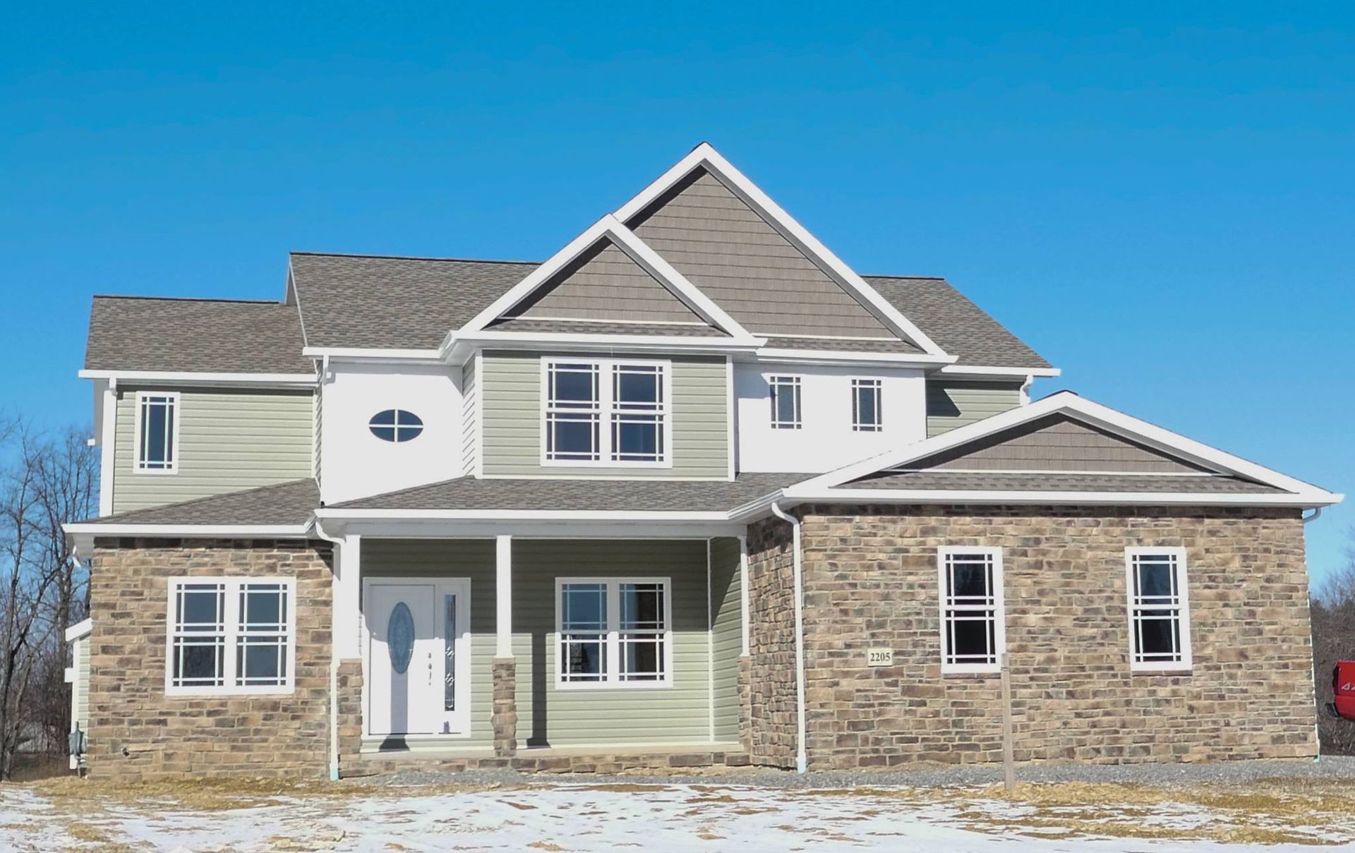 A large house with a lot of windows and a porch