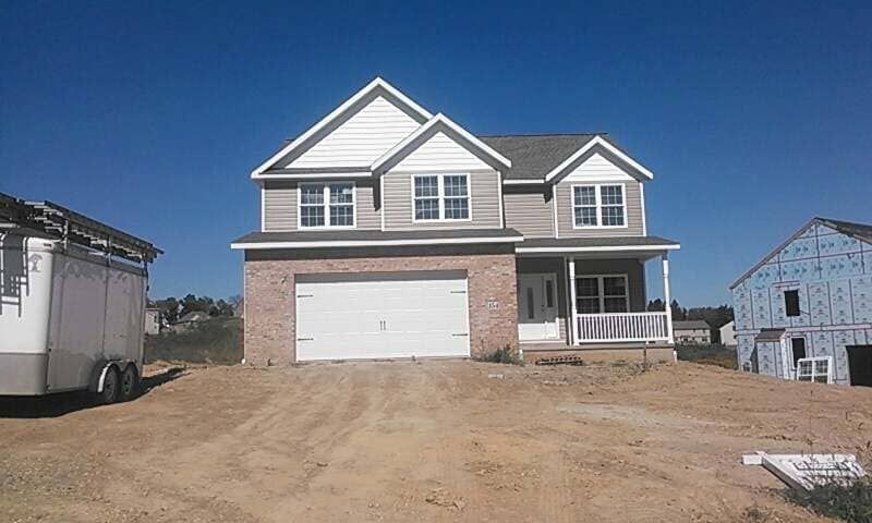 A house under construction with a trailer parked in front of it.