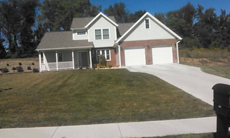 A house with two garages and a driveway in front of it