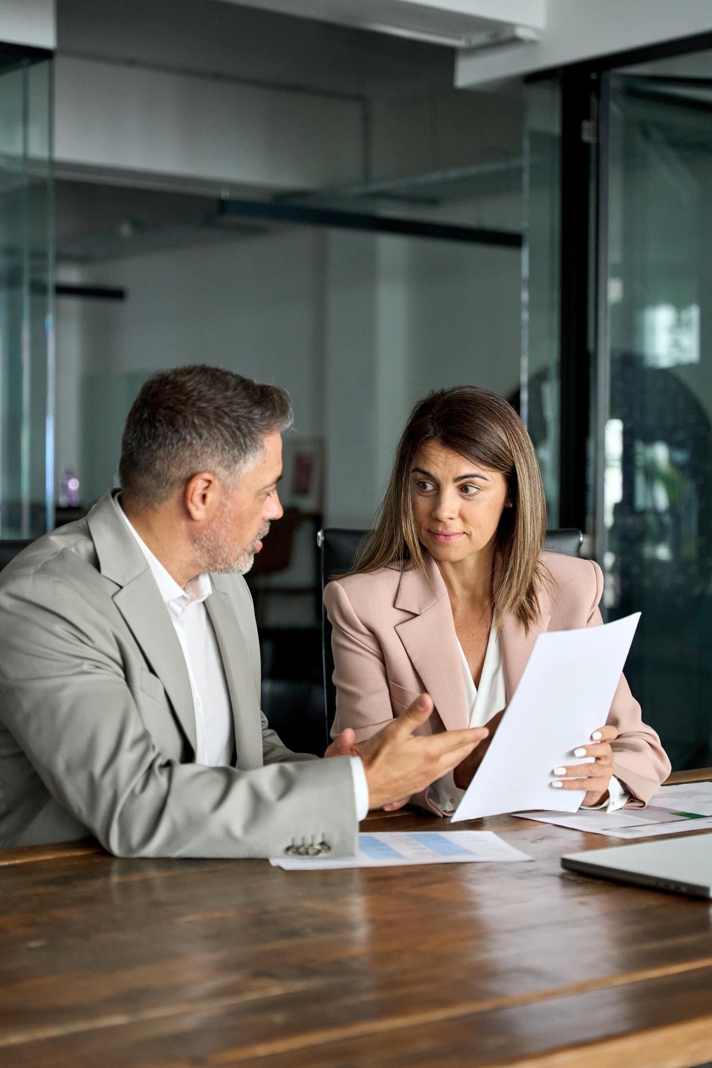 Man and woman reviewing documents at a table. 