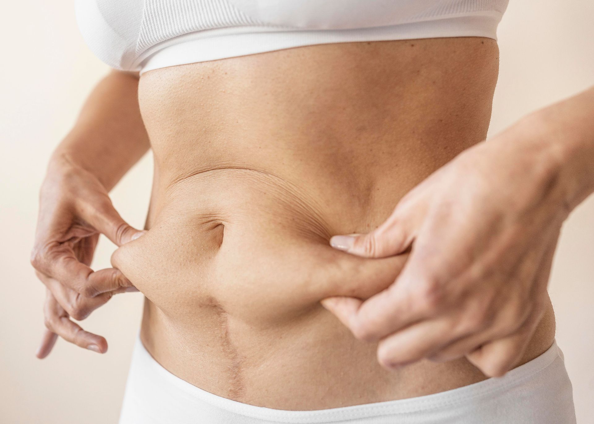 A woman is holding her stomach with her hands.