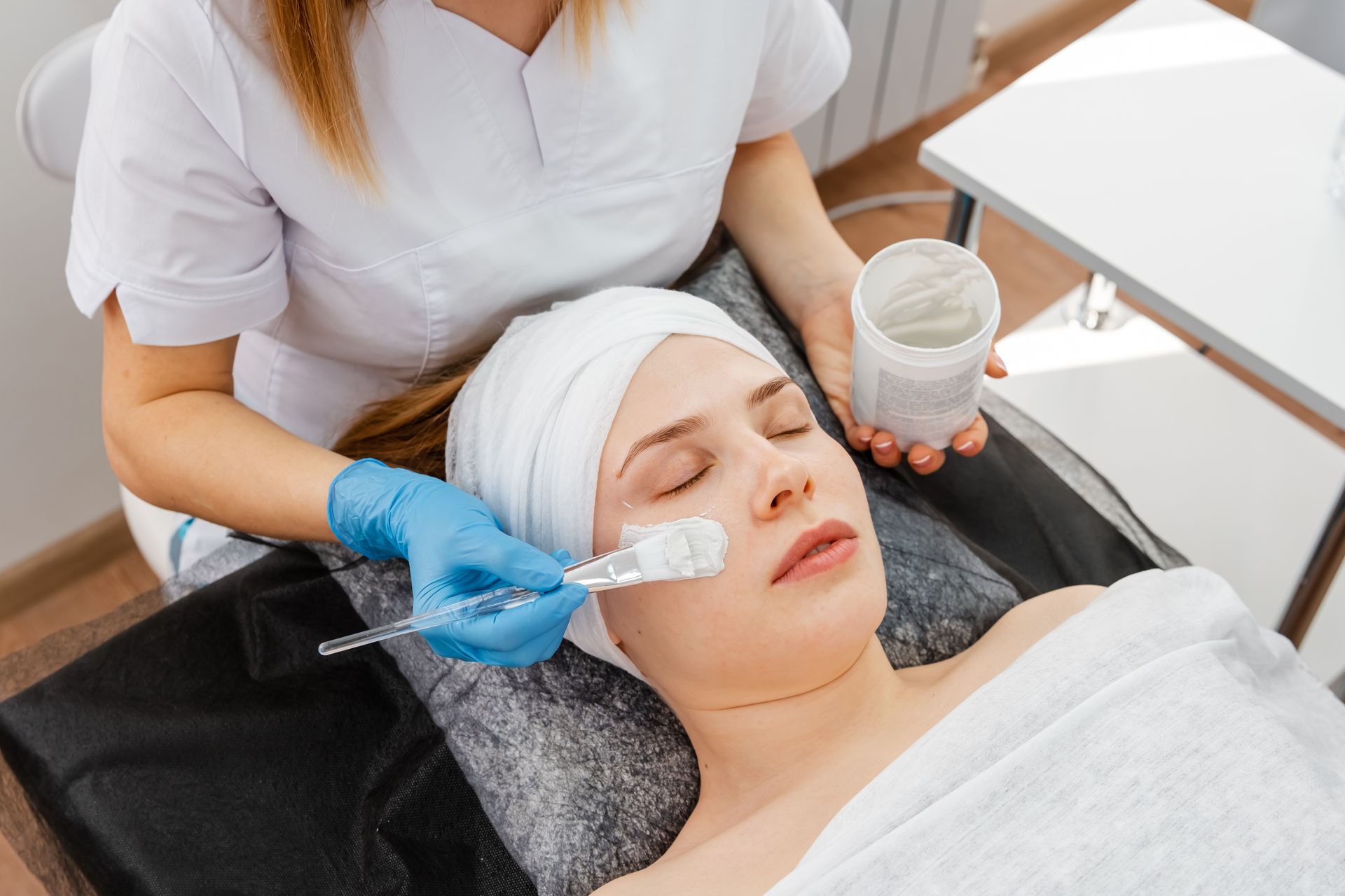 A woman is getting a facial treatment in a beauty salon.