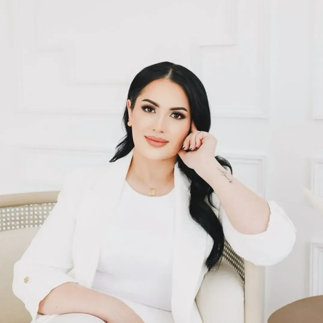 A woman in a white jacket is sitting in a chair