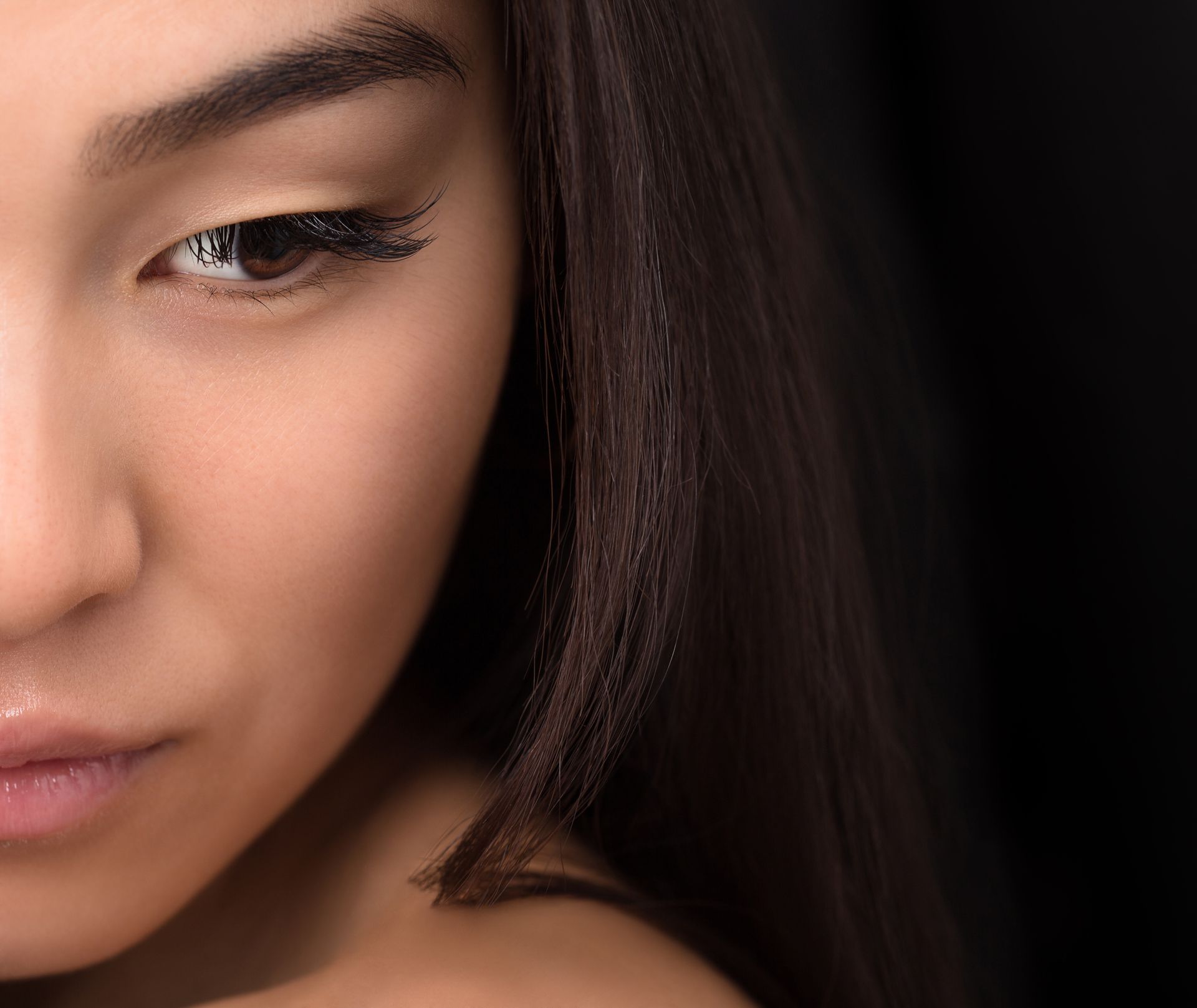 A close up of a woman 's face with a black background.