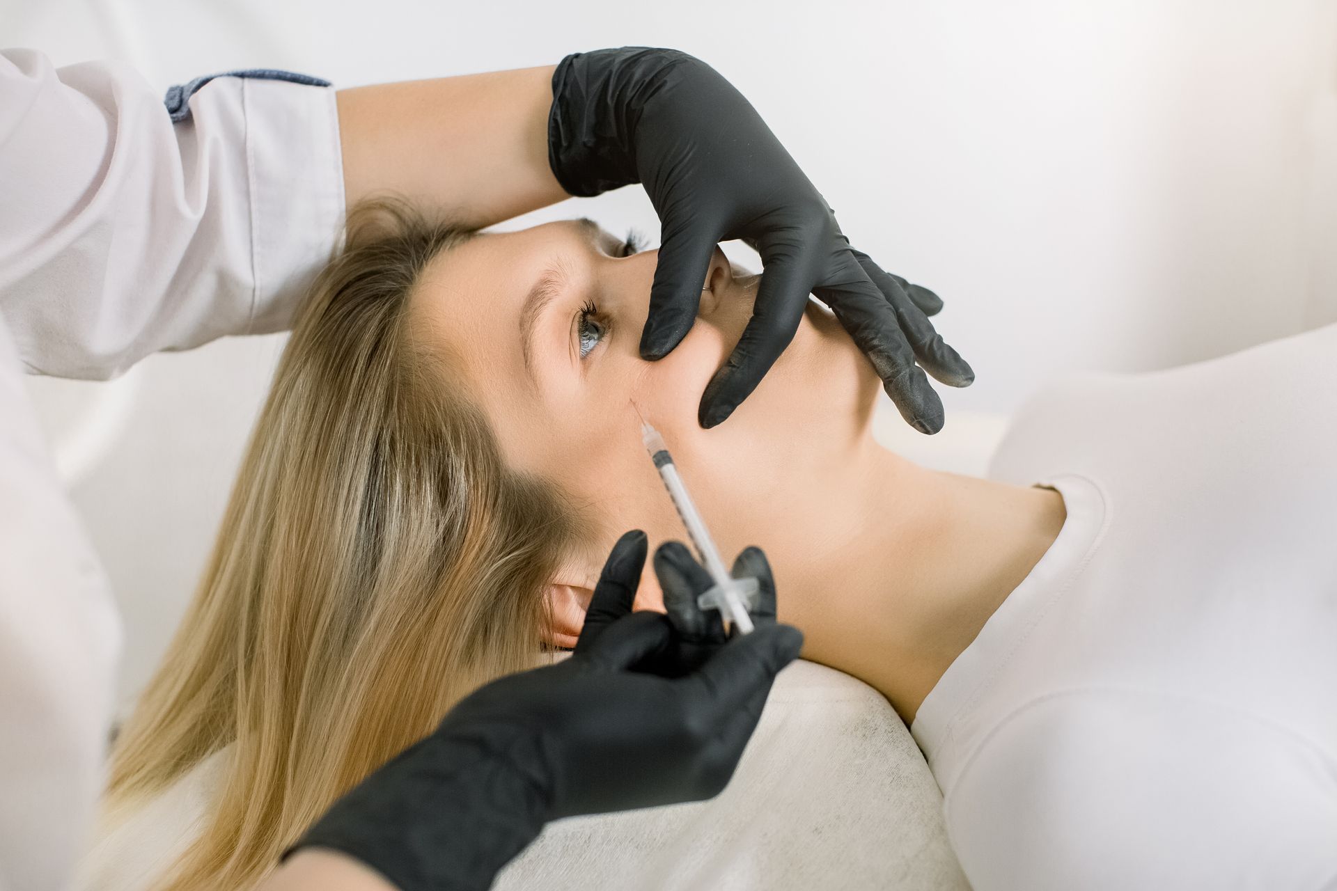 A woman is getting a botox injection in her face.