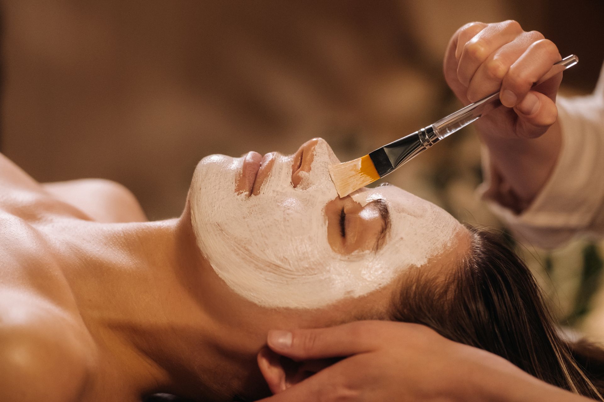 A woman is getting a facial treatment at a spa.