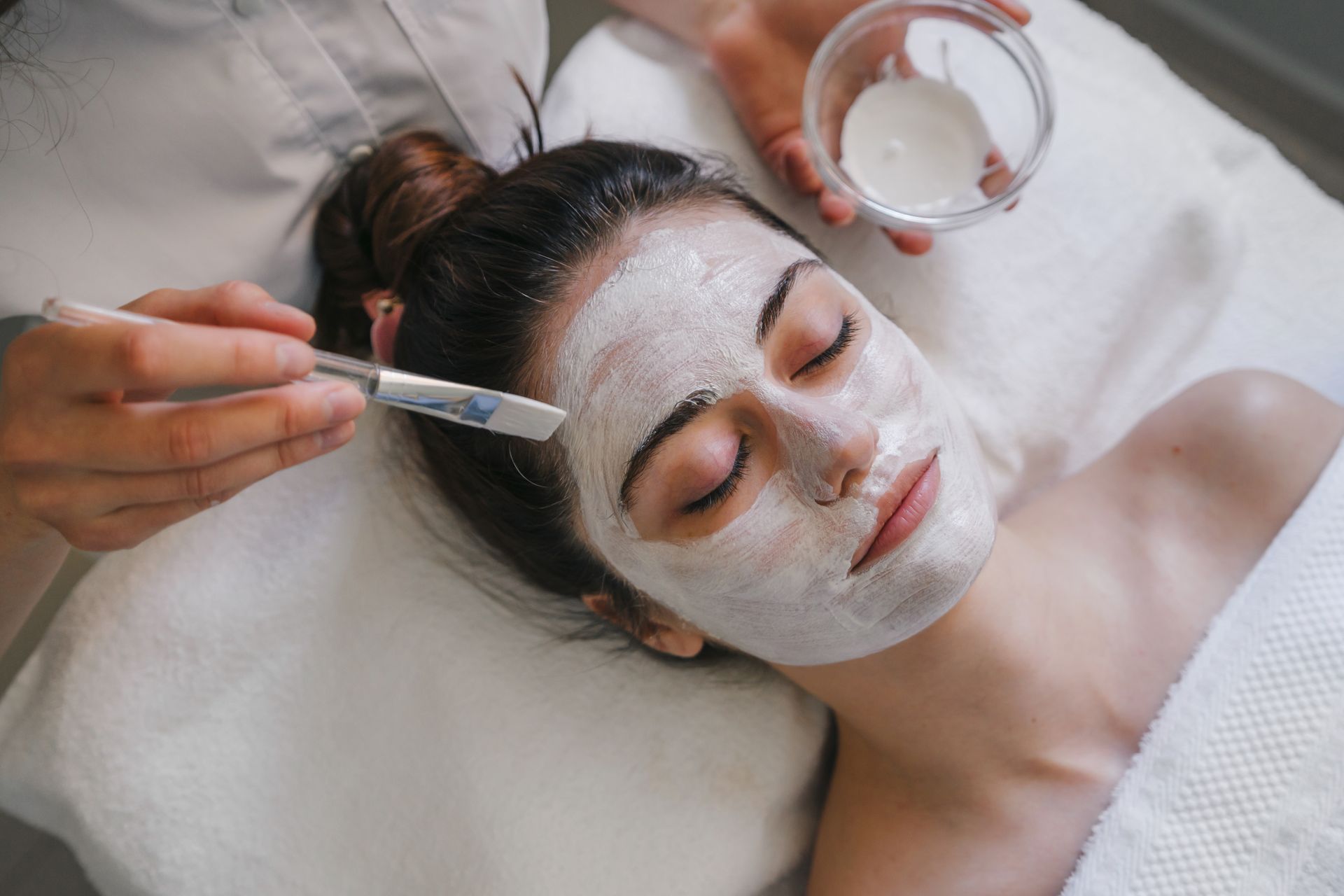 A woman is getting a facial treatment at a spa.