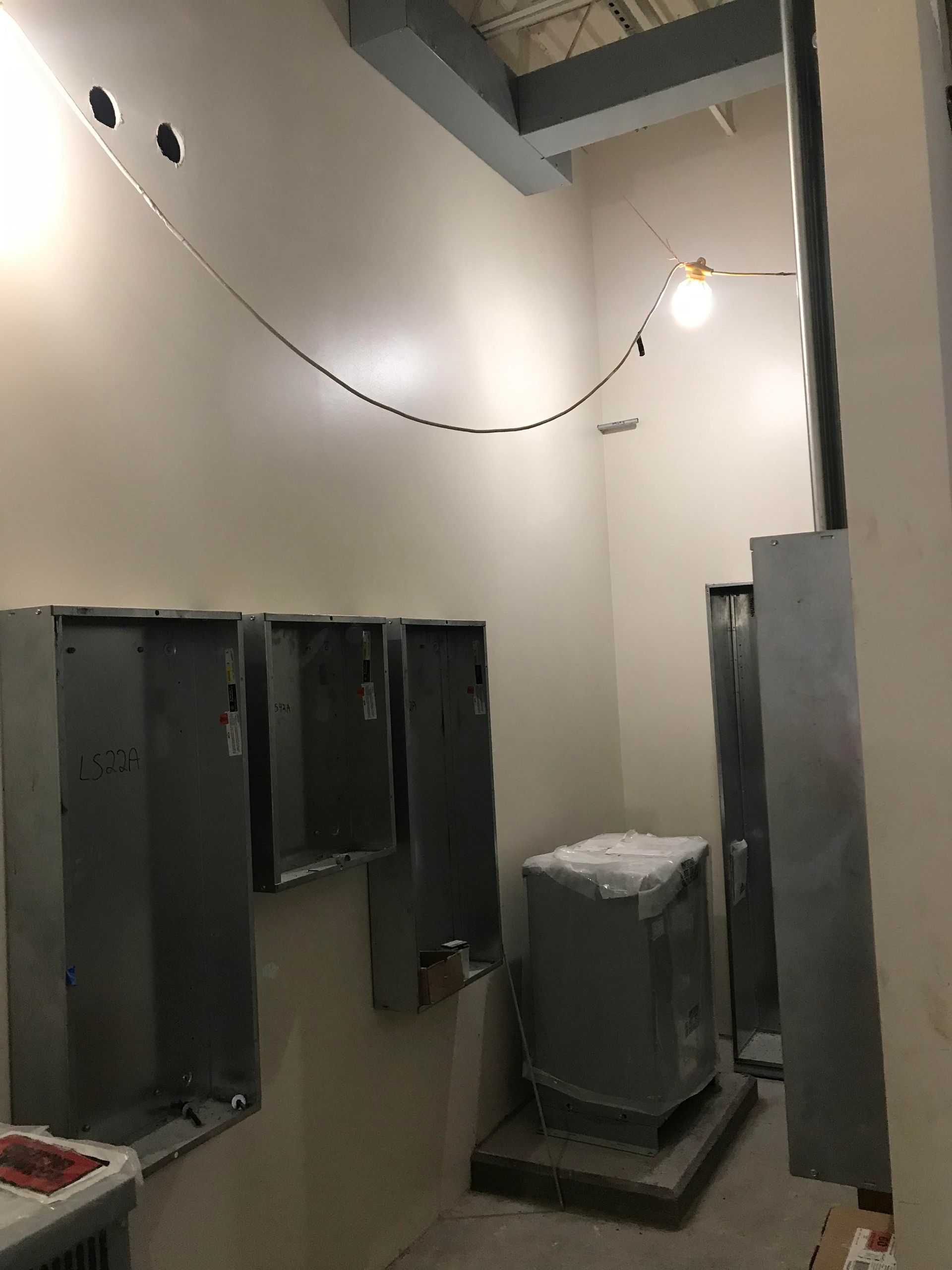 Empty metal electrical boxes and conduit on wall in a construction site.