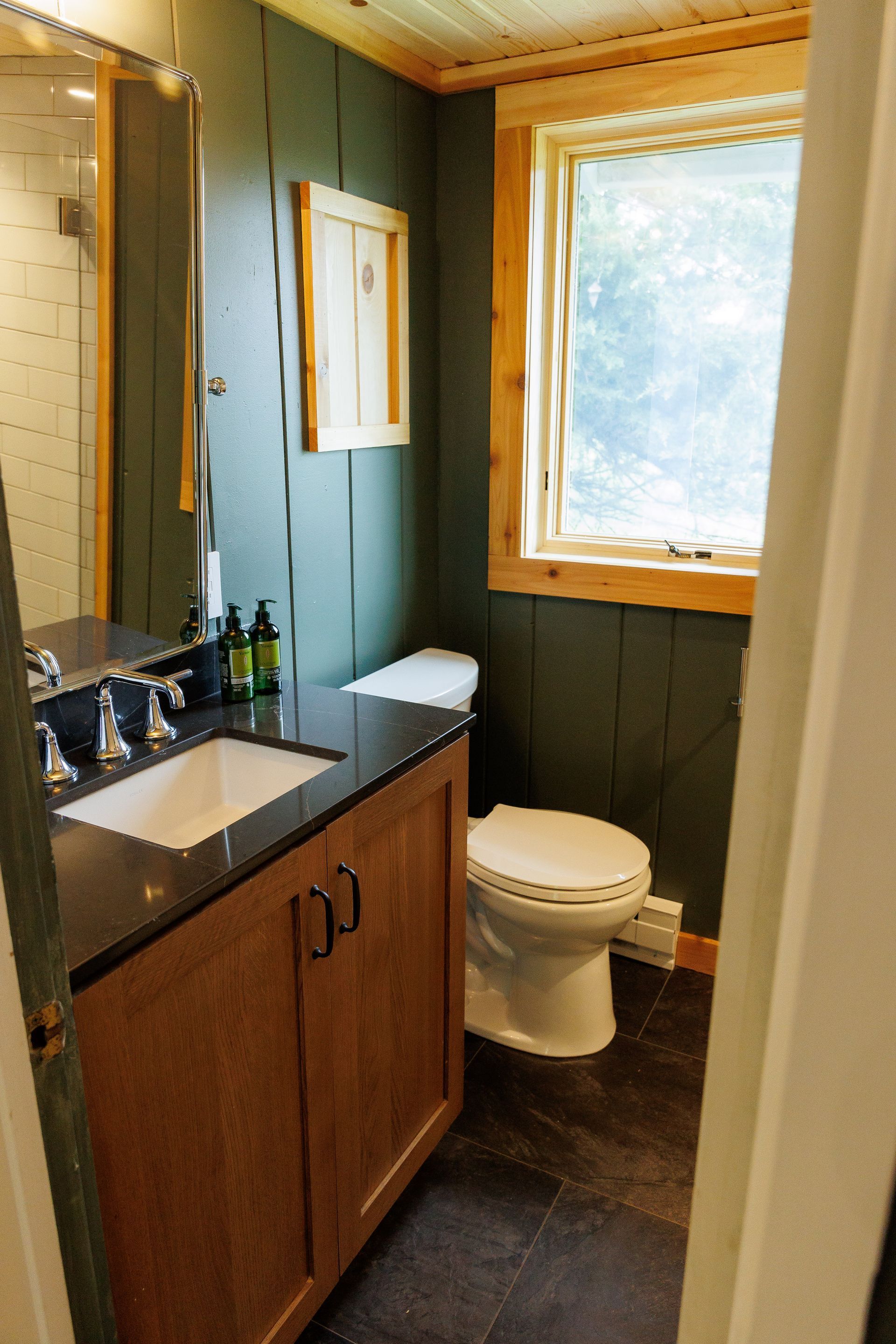 A bathroom with a toilet a sink and a window