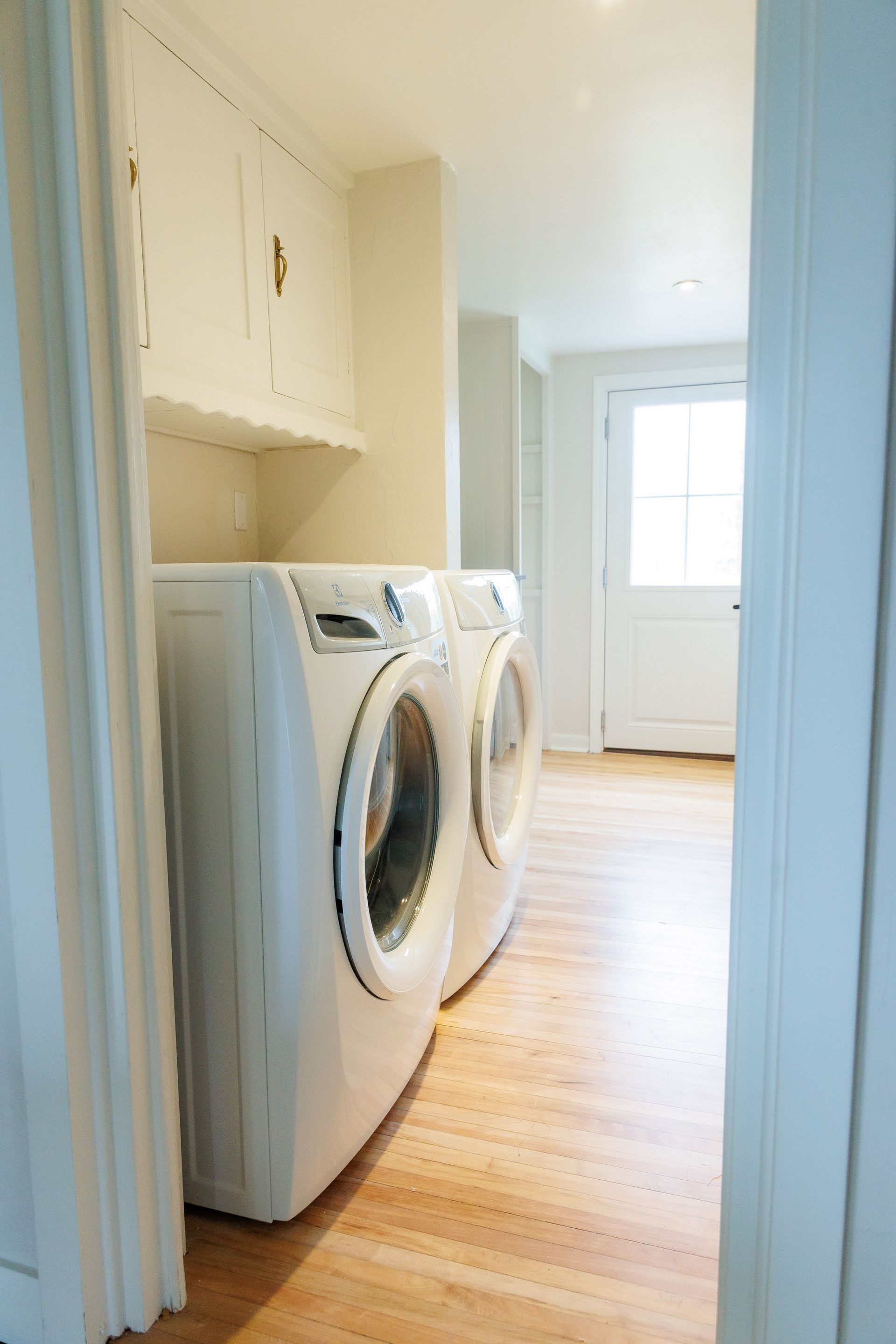 A laundry room with two white washers and dryers.