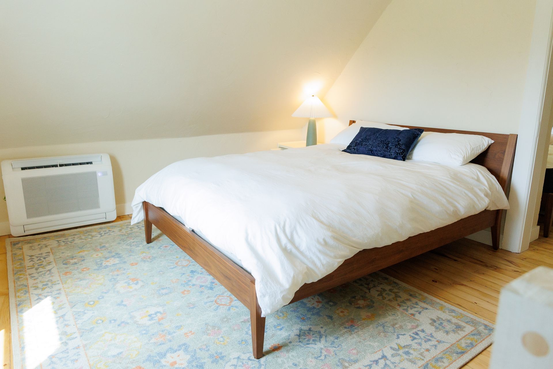 A bedroom with a king size bed and a rug.