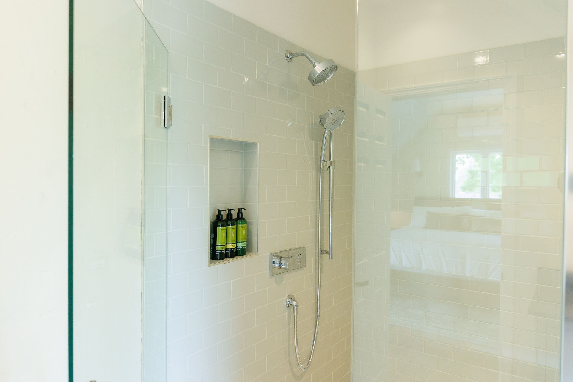 A bathroom with a walk in shower and a glass door.