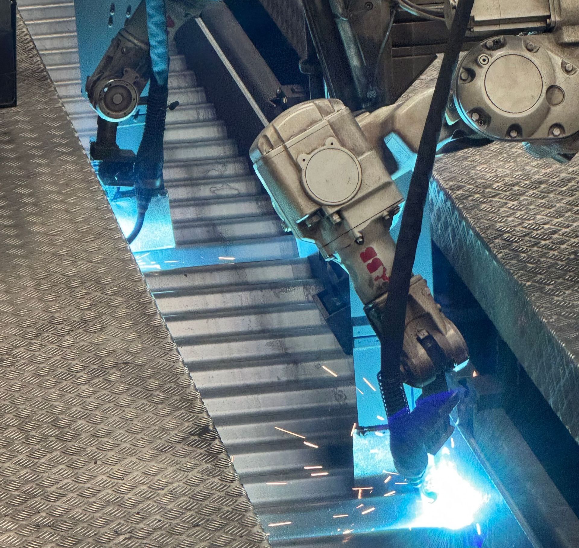 A robotic arm is welding a piece of metal