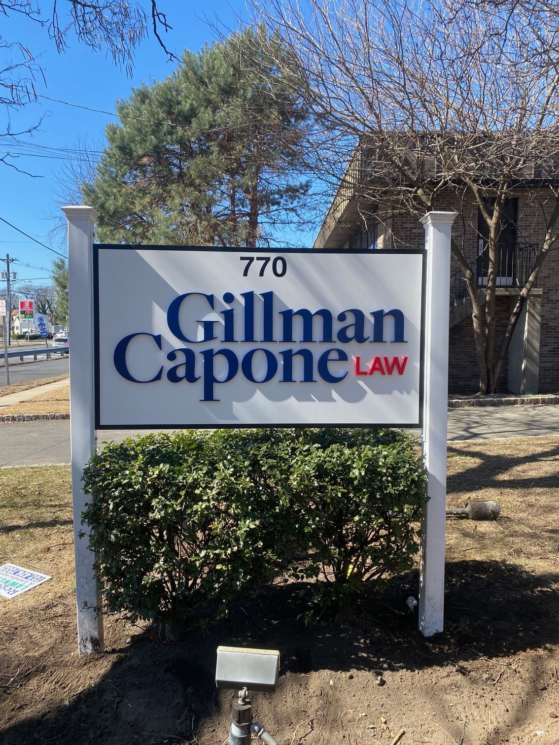 Gillman Capone Law sign with address 770 in front of a building and trees