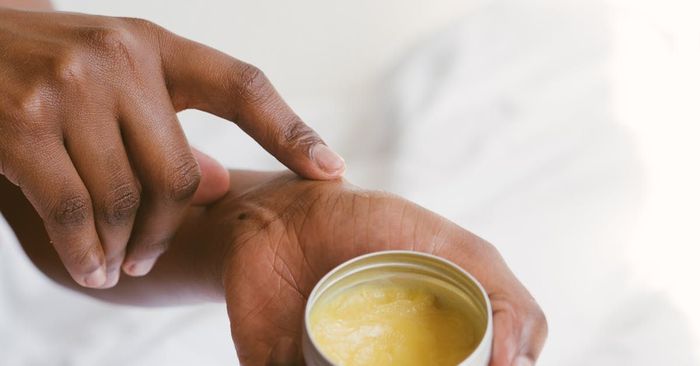A person is applying lotion to their wrist.