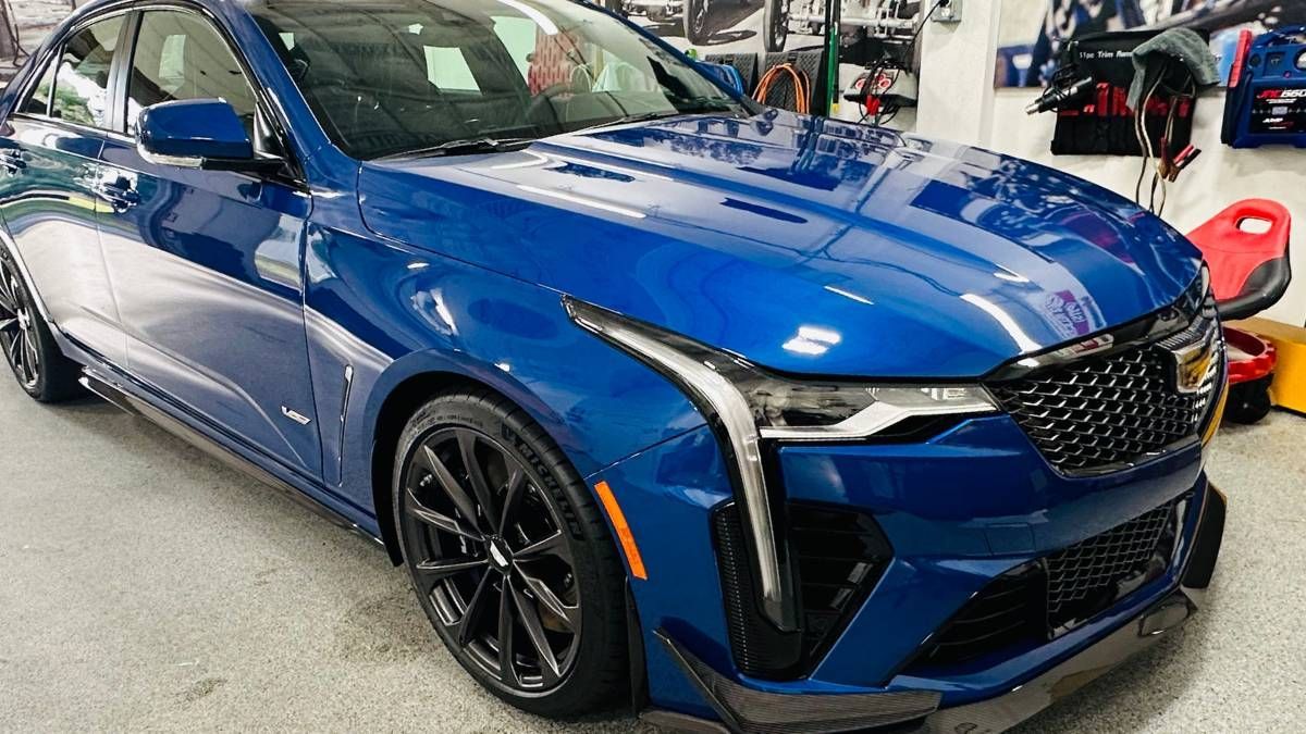 A blue car is parked in a garage.