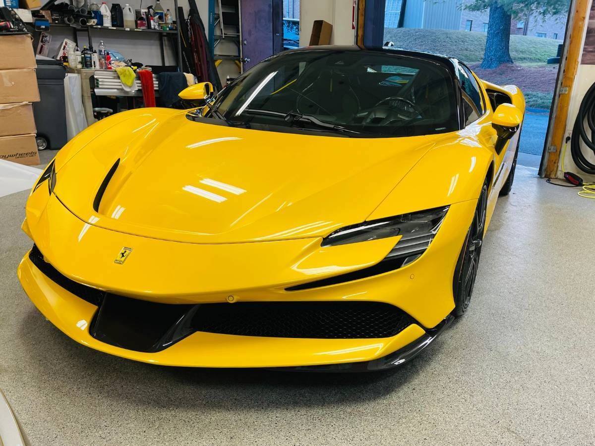 A yellow sports car is parked in a garage.