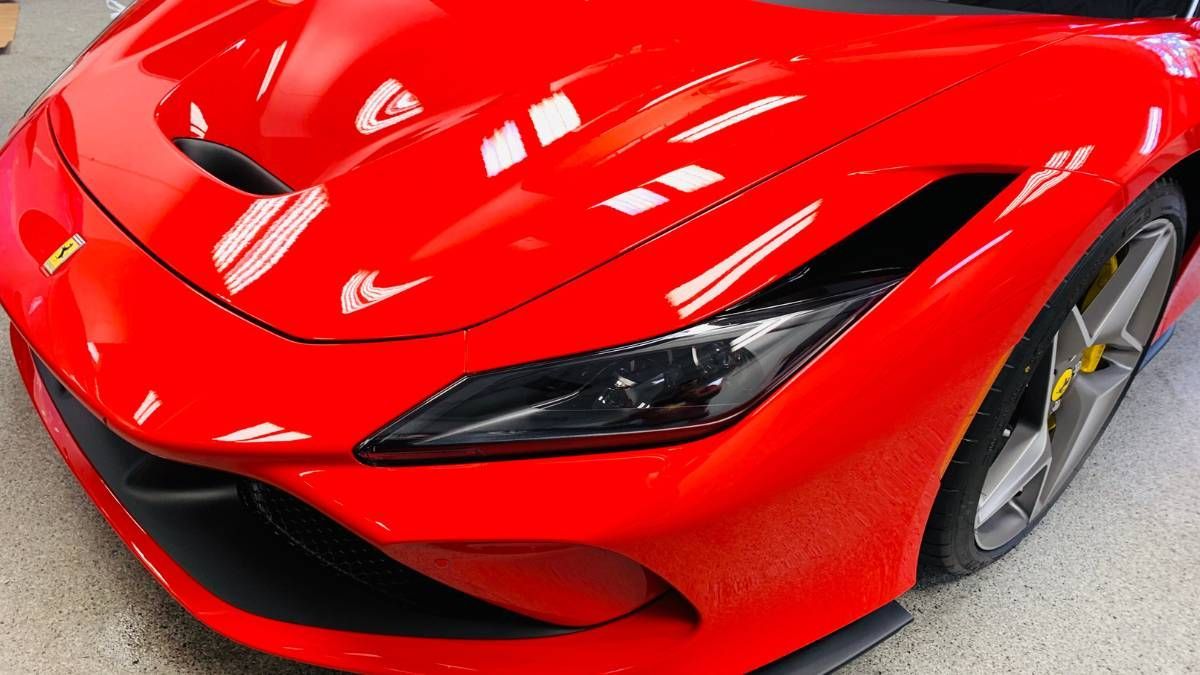 A red sports car is parked in a garage.
