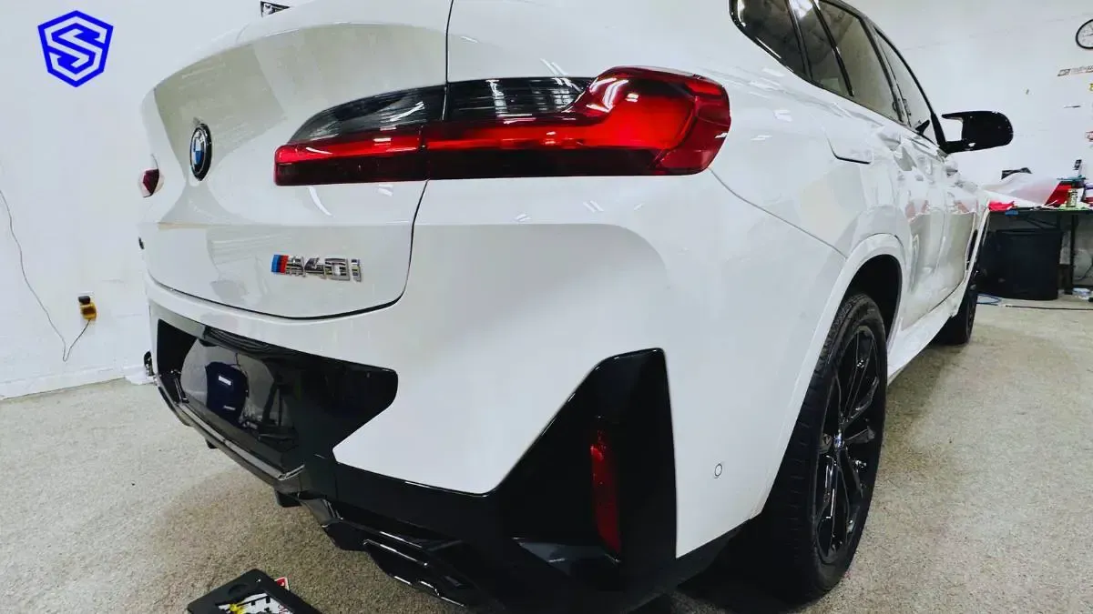 A white bmw x4 m is parked in a garage.