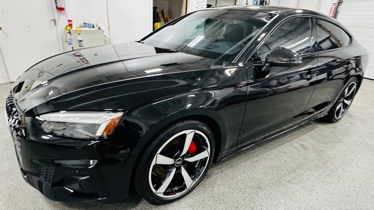 A black car is parked in a garage.