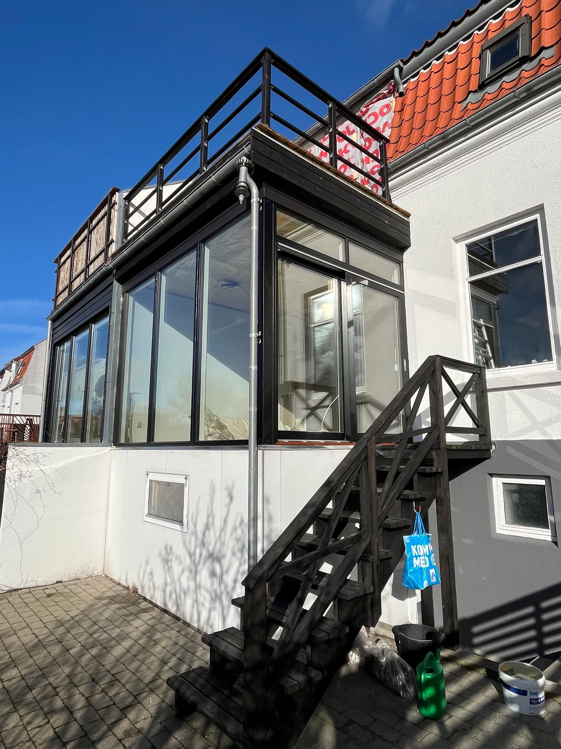 Et hvidt hus med balkon og trapper der fører op til det